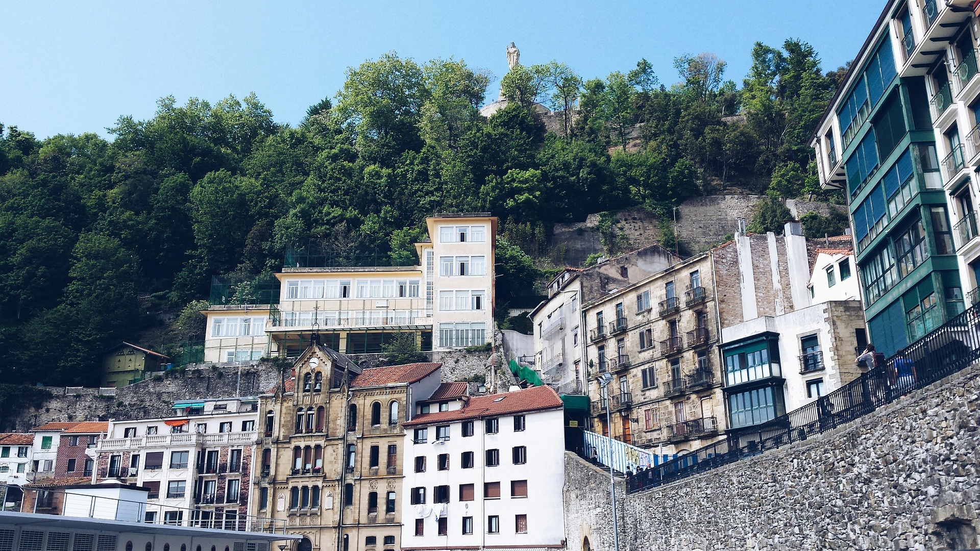 Fachadas de la Parte Vieja de San Sebastián bajo el monte Urgull y la estatua del Sagrado Corazón.